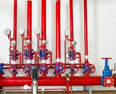 Various red pipes carrying water to a fire alarm system