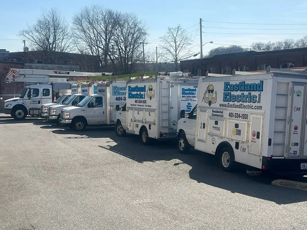 Lineup of Eastland electrical box truck fleet with bucket truck at the end on a sunny day